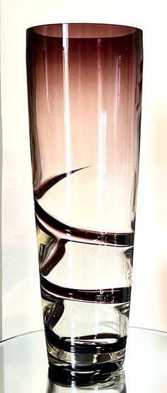 a close up of a glass on a table with water in the bottom and an object behind it