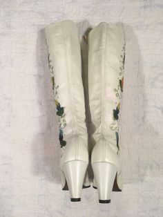 "1960s / early 70s GoGo boots white leather lace up embroidered floral detail w/tiny metal studs around the embroidery the flowers are embroidered patches and edges curl up a bit rubber heel and sole caps good vintage condition, light wear light scuffs, stains, age wear instep of right boot has a slight gap between sole and leather when worn the foot should secure this area w/it's weight could be taken to shop to secure *priced w/the possibility of that cost in mind label size 9 M, fit me true t White Embroidered Boots For Winter, Spring White Embroidered Boots, Spring Embroidered White Boots, Retro High Heel Boots For Spring, Vintage Summer Boots With Round Toe, Vintage White Boots For Spring, White Vintage Boots For Spring, White Embroidered Round Toe Boots, Vintage Fitted Boots With Almond Toe