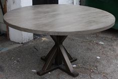 a round wooden table sitting in front of a building