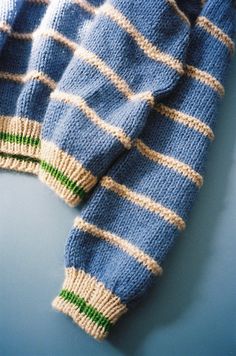 a blue and white striped sweater sitting on top of a table