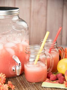 two mason jars filled with drinks next to some fruit