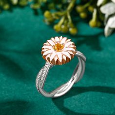 Daisy flowers represent innocence and they are usually linked to children or newborns, it is also a symbol of a new beginning. Beautifully handcrafted in sterling silver, this ring features a charming daisy and two rows of petite pave-set round brilliant-cut stones intertwine for a timeless style. The top part of the ring is rotatable, can be spun smoothly. Stunning and sparkling, this nature-inspired ring will capture your heart at first sight.Carat Weight: 0.15 ctStone Size: 3.5 mmStone Type: Jeulia® StoneNumber of Stones: 1 Stone Shape: RoundStone Color: Citrine YellowCarat Weight: 0.74 ctStone Size: 1 mmStone Type: Jeulia® StoneNumber of Stones: 74 Stone Shape: RoundStone Color: Diamond WhiteWeight: 5.6 gWidth: 3.9 mmHeight: 6.4 mmThickness: 1.5 mmMaterial: 925 SilverPlating Color: Sil White Gold Flower Ring In Fine Jewelry Style, White Flower Ring In Fine Jewelry Style, White Gold Flower Ring With Birthstone, Fine Jewelry Flower Ring With Birthstone In Sterling Silver, Rose Gold Sterling Silver Flower Rings, White Gold Flower Shaped Ring For Promise, White Gold Flower Jewelry For Birth Flower, Dainty White Gold Flower Ring, Fine Jewelry White Gold Flower Ring