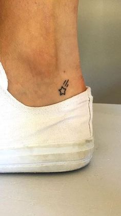 a person with a small star tattoo on their left ankle and the word love is written in black ink