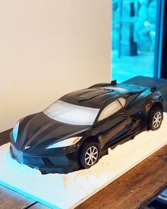 a black toy car sitting on top of a table