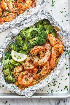 shrimp and broccoli wrapped in foil with lemon wedges, parsley on the side