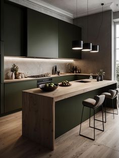 a modern kitchen with green cabinets and counter tops, along with stools that match the wood flooring