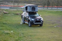 a truck with a camper attached to it parked in the grass