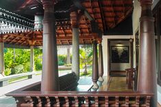 the inside of a house with wooden pillars and columns on either side of the porch