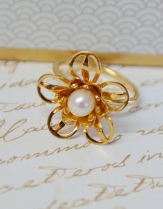 Pearl Flower Ring, Gold Pearl Ring, Pearl Bridal Ring, Wedding Jewelry, White Pearl Ring, Unique Flower Ring, Wedding Ring, Gift for WomenThis is a stunning, feminine gold pearl flower ring that works well for all occasions, styles, and ages. You will love it!Jewelry design inspired by mother earth and flowers blossoming in the spring.This ring is unique and elegant designed in the shape of a Sweet Bay Flower.The ring made of brass plated with 22K gold and inlaid with white pearl.The ring will b Elegant Gold Flower Ring For Wedding, Elegant Flower Rings For Anniversary, Elegant Flower-shaped Rings For Anniversary, Elegant Flower Shaped Ring For Anniversary, Elegant Flower Ring For Anniversary, Elegant Yellow Gold Flower Ring For Wedding, Elegant Wedding Rings With Flower Shape, Elegant Yellow Gold Wedding Flower Ring, Elegant Flower Shaped Wedding Rings