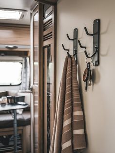 towels are hanging on the wall in front of an rv's dining room table