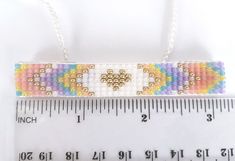 a beaded bracelet is shown next to a ruler