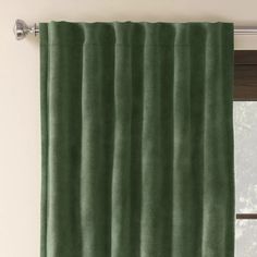 a green curtain hanging on the side of a window