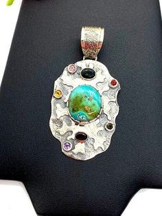 "ARTISAN TURQUOISE TOURMALINE PENDANT Hand-made Sterling Silver 925. Stones used: Turquoise(Nevada), Green Tourmaline, Pink Tourmaline, Red Sapphire, Citrine, Amethyst, Garnet. Height -2 3/4\" (including bail), Width - 1 6/16\" Height - 72mm (including bail), Width - 35mm Unique Handcrafted One-of a-kind Design Pendant Each Piece of Jewelry in my Collection is Absolutely One of a Kind! When you start wearing a piece of my jewelry you will fall in love with it more and more each day and feel that Unique Turquoise Pendant Necklace, Artisan Turquoise Stones Necklace For Gift, Artisan Turquoise Necklace With Stones As Gift, Unique Multicolor Gemstones In Sterling Silver, Artisan Turquoise Stone Necklace, Unique Multicolor Sterling Silver Gemstones, Unique Turquoise Pendant Necklace With Stones, Artisan Turquoise Pendant Necklace, Handmade Multicolor Sterling Silver Turquoise Necklace