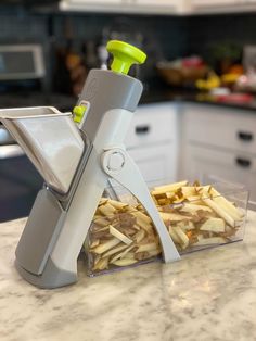 a close up of a food slicer on a counter top with french fries in it