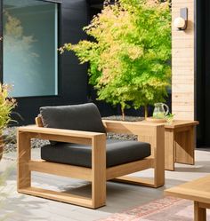 a chair and table sitting on a patio with trees in the backgrouund