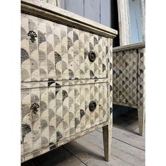 an old dresser has been painted with black and white designs on it's drawers