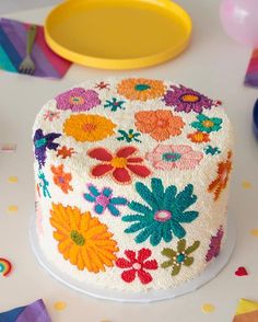 a decorated cake sitting on top of a table next to plates and confetti