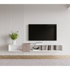 a flat screen tv sitting on top of a white shelf next to a vase filled with flowers