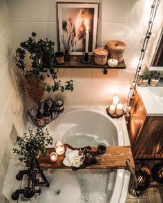 a bathtub with candles and plants in it