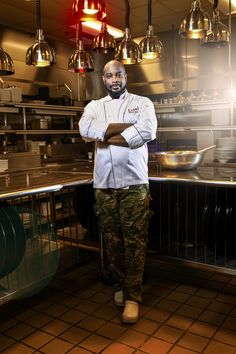 a man standing in a kitchen with his arms crossed