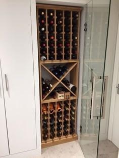 a wine rack in the corner of a room next to a walk in shower with glass doors