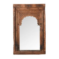 an old wooden mirror with carvings on the front and sides, sitting against a white wall