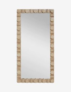 a mirror made out of wooden blocks with circles on the front and sides, hanging from a wall