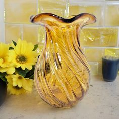 a yellow glass vase sitting on top of a counter