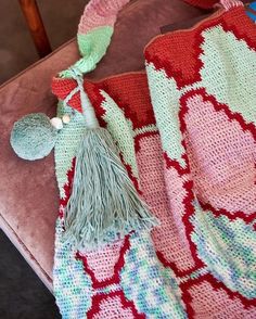 a crocheted blanket with a tassel on it