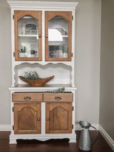 a white china cabinet with wooden doors and drawers