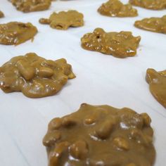 cookies with peanut butter on them sitting on a sheet of white paper and covered in brown icing