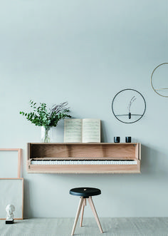 a piano sitting on top of a wooden shelf next to a vase filled with flowers