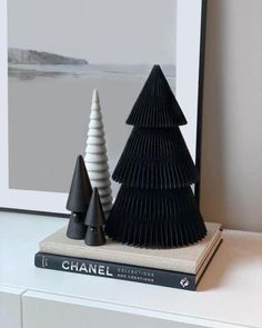 two black and white trees sitting on top of a book shelf next to each other