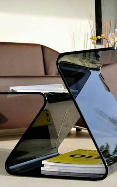 an upside down glass table sitting on top of a white floor next to a couch