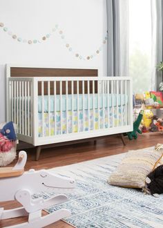 a baby crib in the middle of a room with toys and other items on the floor