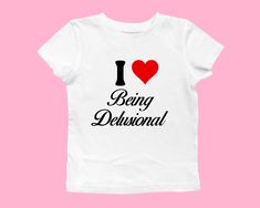 I heart being delusional baby tee ❤️ ♡ Please let me know if you need any custom designs that is not listed, I'll happily custom-make it for you! ♡ 🌟SIZING Please find the size chart in listing photo before purchasing. We recommended measuring a t-shirt you already own to get the best fitting t-shirt.  💖CARE/ WASH Machine wash: warm (max 40C or 105F); Non-chlorine: bleach as needed Tumble dry: medium heat; Iron, steam or dry: low heat; Do not dry clean. ✨SHIPPING Custom orders may take longer Baby Tee Sayings, I Heart T Shirt, Baby Tee Outfit Aesthetic, I Heart Shirts, I Love Being Delusional, Love Being Delusional, I Love Shirts, Being Delusional, I Love Shirt