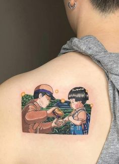 a woman with a tattoo on her back has an image of two people eating food