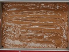 a pan filled with chocolate frosting sitting on top of a table