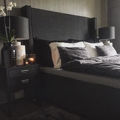 a bedroom with a bed, night stand and two lamps on either side of the bed