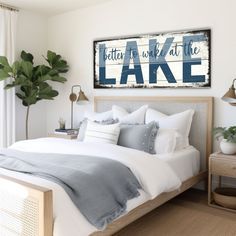 a bedroom with a bed, nightstands and paintings on the wall above it that says better you will at the lake