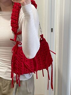 a woman is taking a selfie with her cell phone while wearing a red knitted scarf