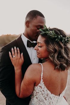 a bride and groom embracing each other in the desert