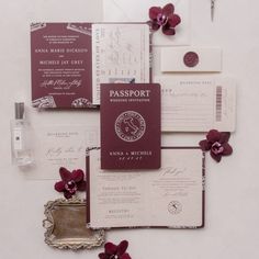 an assortment of wedding stationery items including passport cards, envelopes and flowers on a white surface