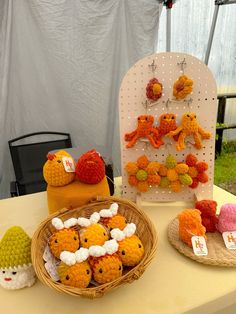 there are many crocheted animals on display in this tableclothed area, and one has a basket full of them