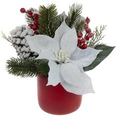 a red vase with white flowers and greenery on the inside is filled with snow