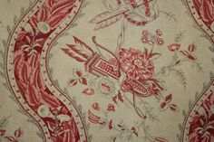 a red and white floral design on a tan background with birds, flowers, and leaves