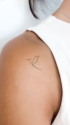 a woman's arm with a small tattoo on the left side of her shoulder