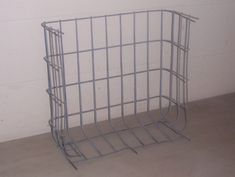 a metal cage sitting on top of a floor next to a wall