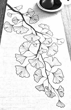 a black and white drawing of leaves on a table