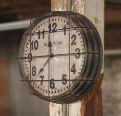 a clock that is hanging on the side of a building with numbers painted on it